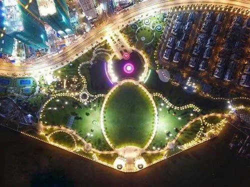 Hàng dừa nghiêng nhẹ trước nền skyline cao tầng, ánh nắng chiếu xiên tạo chiều sâu cho bức hình tại công viên Landmark 81 sang trọng