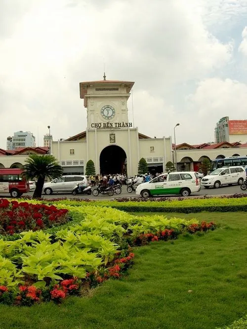 Một góc vườn hoa phía trước cổng, bồn cây cắt tỉa gọn gàng, phía sau là tháp đồng hồ quen thuộc của địa danh lịch sử Sài Gòn tạo cảm giác yên bình hiếm thấy