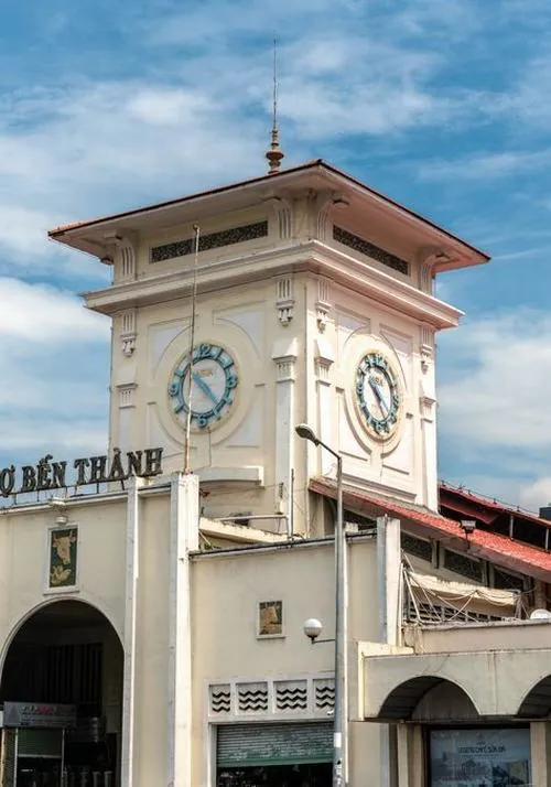 ảnh trái tim thành phố bắt khoảnh khắc chiều xuống, ánh đèn bắt đầu lên, tháp đồng hồ nổi bật giữa nền trời xám nhẹ, tạo cảm giác luxury nhưng vẫn gần gũi