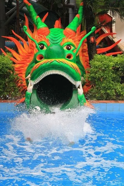 Ảnh công viên nước Đầm Sen dòng nước xanh bắn tung từ miệng rồng lớn, người chơi lao xuống đầy phấn khích trong khu vui chơi dưới nước Đầm Sen rực rỡ