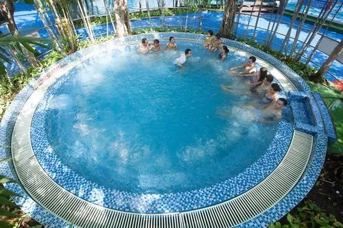 Mặt hồ tạo sóng tròn đều, làn nước gợn nhẹ phản chiếu ánh nắng, người bơi rải rác tận hưởng sự mát mẻ giữa điểm vui chơi giải trí nước Sài Gòn