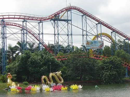 Trải nghiệm ở công viên nước Đầm Sen với đường trượt cao uốn lượn, người chơi lao xuống tạo splash mạnh trong khung cảnh sống động đầy năng lượng