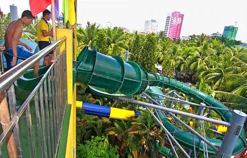 Không gian công viên nước Đầm Sen nổi bật với hệ thống ống trượt nhiều tầng xanh vàng, người chơi nối nhau trải nghiệm cảm giác mạnh đầy cuốn hút