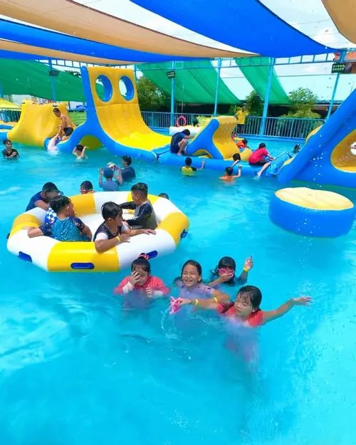Không gian hồ chơi trẻ em cho thấy nhiều người ngồi trên phao nổi giữa làn nước xanh trong tại khu vui chơi dưới nước đông vui của Beryland