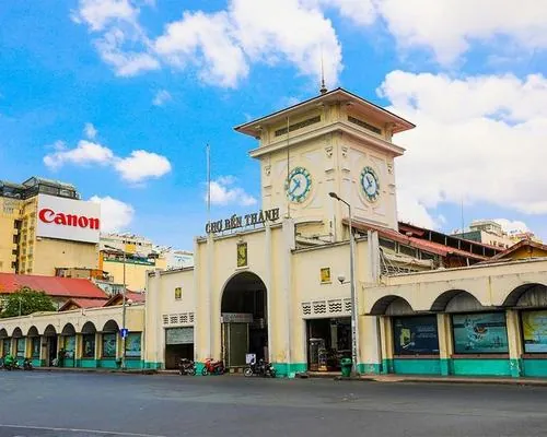 Một nhóm du khách đứng xem hàng lưu niệm, vừa chọn vừa trao đổi, tiếng cười nói làm không gian trở nên rộn ràng hơn