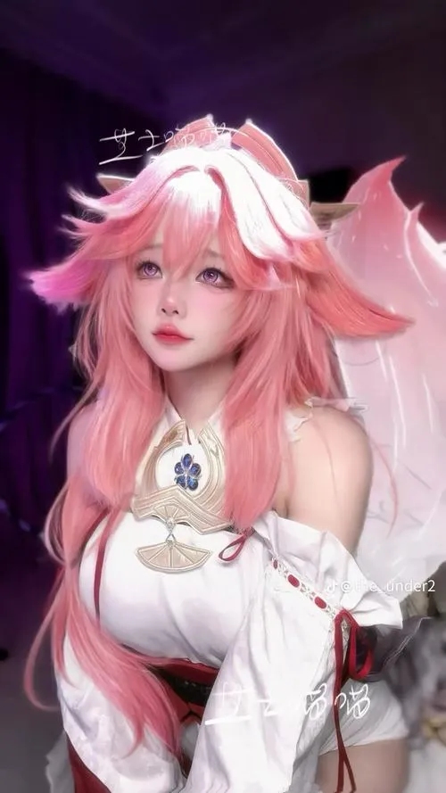 Mỹ nữ tóc hồng mặc áo lót đỏ lấp lánh tay nâng ngực ánh mắt hướng thẳng.