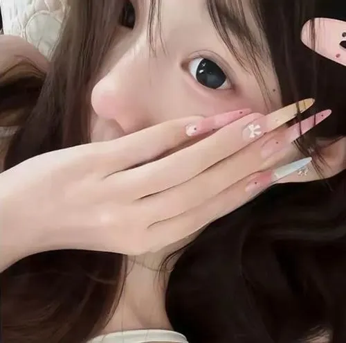 Thiếu nữ nằm úp mặt vào gối lông trắng, tóc đen dài xõa tung, áo trắng mỏng manh trong góc chụp gần.