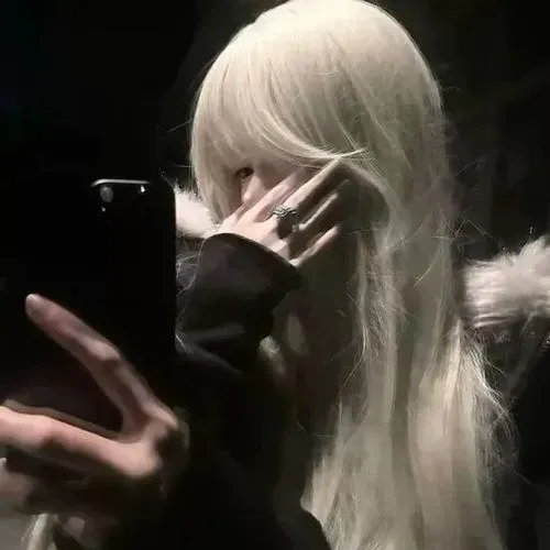 Mỹ nhân đứng sau lưng quay mặt che bằng tóc dài trong váy trắng, nền phố đêm lung linh ánh đèn quyến rũ.