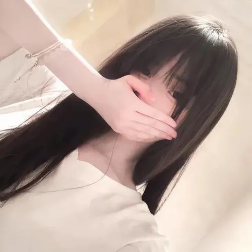 Gái xinh đeo kính gọng tròn che miệng bằng khăn sọc, tóc nâu dài, áo len sọc trong phòng.