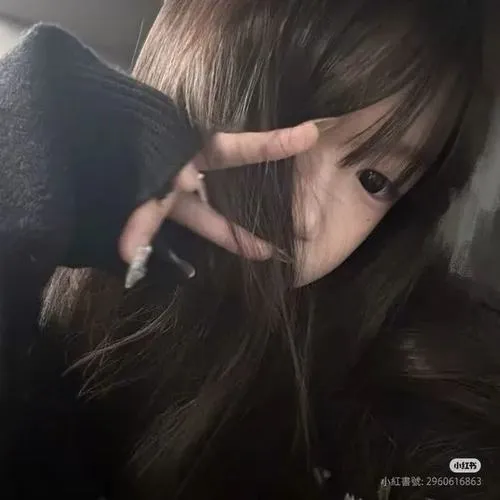 Hot girl che mặt bằng ngón tay tạo hình V, tóc đen dài che một bên mắt, áo khoác ngoài mỏng khoe vai trong không gian trong nhà.