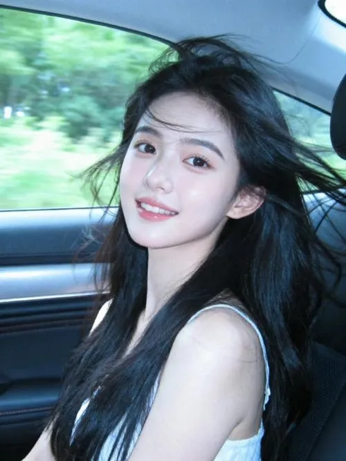 Gái xinh ngồi trong xe hơi tóc dài bay nhẹ mỉm cười nhìn camera với đôi mắt lấp lánh toát lên sự tự nhiên và nụ cười tỏa nắng.