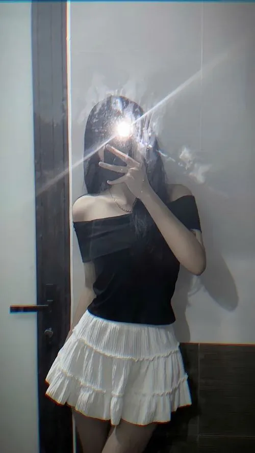 Mặc áo đen off shoulder khoe vai tóc dài thẳng đứng che mặt bằng điện thoại đầy tự tin.