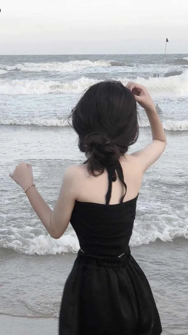 Hot girl che mặt bằng tóc ngồi bên cửa sổ nhìn biển mặc bikini đen da nâu khỏe nắng chiều.