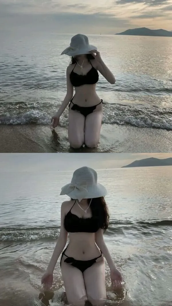 Mỹ nhân ẩn danh đi biển ngồi co gối trên cát mặc hoodie trắng nón xanh dương tay che mắt.