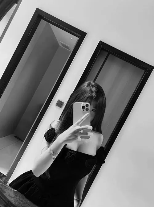 Hình ảnh mỹ nhân che mặt đứng trước gương oval lớn mặc đồ trắng tinh cầm điện thoại che mặt.