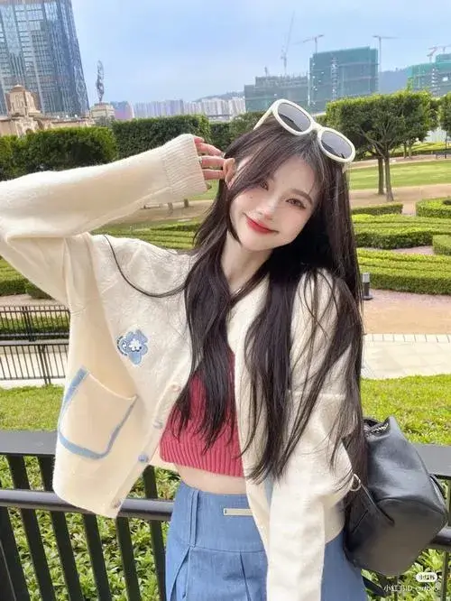 Gái xinh đứng ngoài trời nắng vàng mặc áo khoác trắng oversize tay che mắt cười tươi tóc dài bay nhẹ trông ngọt ngào quyến rũ lắm.