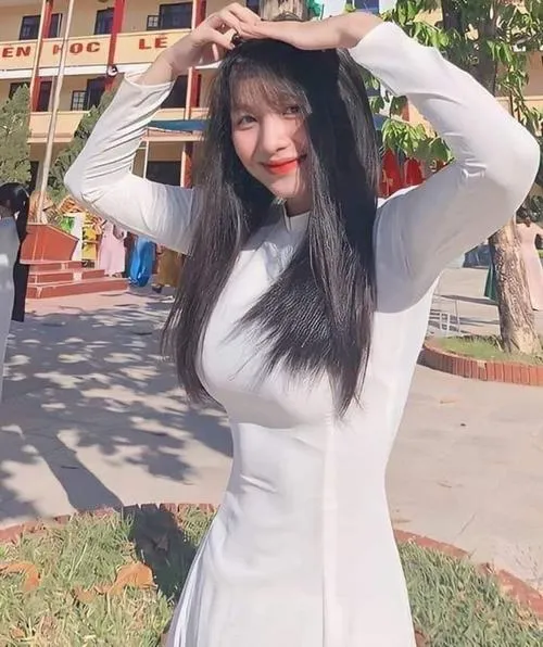 Cô gái mặc váy trắng bó sát giơ hai tay lên trời ngoài trời nắng nụ cười tươi trẻ trung của hot girl 2k7.