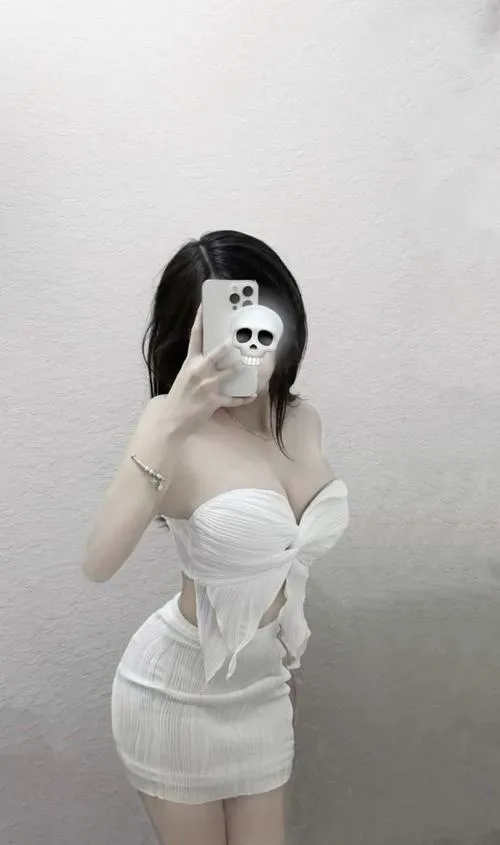 Gái xinh tự sướng trước gương trong chiếc áo corset trắng bó sát tôn ngực đầy đặn tóc đen dài xõa vai nụ cười nhẹ nhàng đôi mắt long lanh trong phòng sáng gái xinh tiktok mặc váy ngắn.