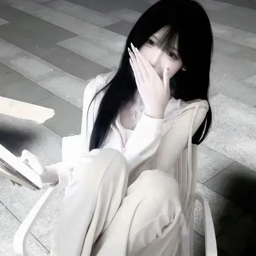 Gái xinh che miệng bằng tay trong outfit học sinh, tóc đen dài nơ xanh, ngồi nhìn camera.