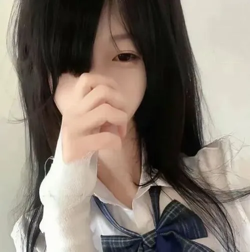 Thiếu nữ đứng ngoài trời mặc váy tối màu che mặt bằng tóc, nền đường phố.