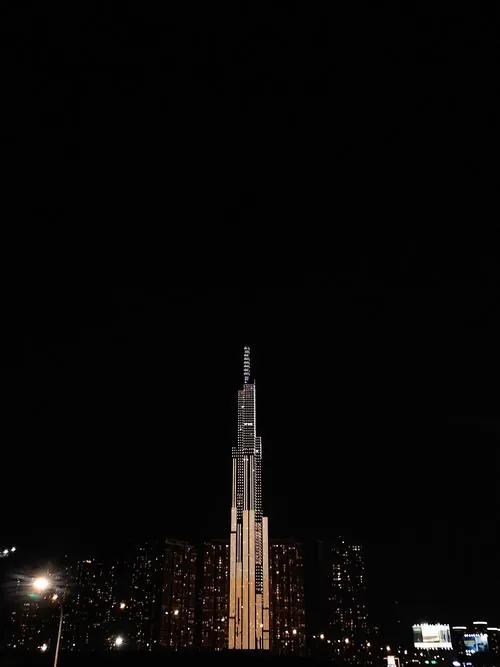 ảnh căn hộ cao tầng khung hình chụp Landmark 81 đứng thẳng giữa nền trời đêm, ánh đèn vàng nhẹ phủ quanh thân tháp, bề mặt kính phản chiếu tạo cảm giác sang trọng và rất đẹp