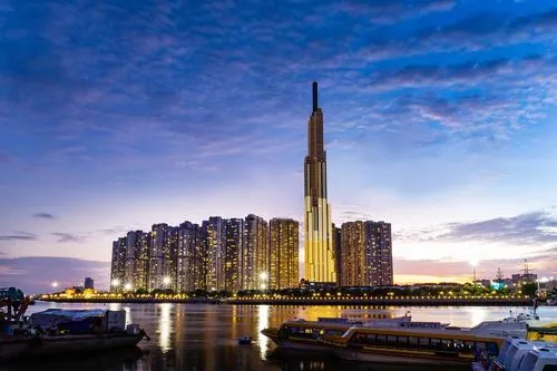 Ảnh hoàng hôn với ánh sáng vàng đổ lên mặt kính, tháp Landmark 81 nổi bật giữa các tòa nhà thấp hơn, mang lại cảm giác sang trọng rõ ràng