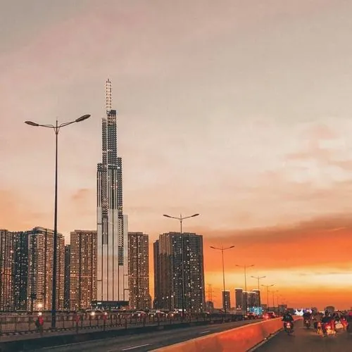 ảnh dự án cao cấp Landmark 81 hiện lên trong buổi chiều đỏ rực, ánh sáng chiếu xiên làm nổi khối kiến trúc bó tre đặc trưng, khung hình có chiều sâu rõ