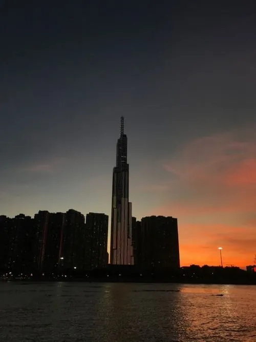 Tòa tháp 81 tầng hiện lên trong khoảnh khắc hoàng hôn đỏ cam, phần đỉnh vươn cao nổi bật giữa skyline Sài Gòn, ảnh Landmark 81 mang vibe ấm và đầy chất đô thị