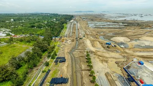 Ảnh thành phố xanh ven biển Cần Giờ ghi lại khu vực bờ kè dài với nhiều phương tiện thi công, mặt nước phẳng lặng giúp tổng thể trông sáng và thoáng