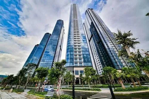 Tòa nhà kính cao vút nhìn từ góc nghiêng, các đường nét thẳng và bề mặt phản chiếu tạo cảm giác luxury rõ rệt giữa trung tâm