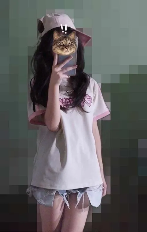 Mỹ nhân áo len mỏng màu be tóc xõa vai ngồi trên giường trắng cầm điện thoại che mặt dịu dàng.