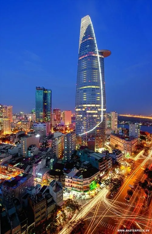 Khung hình cận cảnh phần thân tháp với các tấm kính đa diện phản chiếu mây trời, mang lại cảm giác đẹp nhẹ nhàng nhưng vẫn rất sang