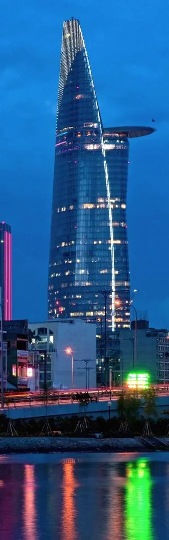 hình chụp biểu tượng Quận 1 với Bitexco đứng thẳng giữa nền trời hoàng hôn cam tím, ánh đèn bắt đầu lên tạo không khí luxury nhẹ và rất cuốn mắt