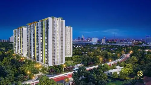 Ảnh chung cư Him Lam Phú An chụp toàn cảnh tòa nhà cao tầng sáng đèn buổi tối, góc nhìn từ dưới lên làm nổi bật kiến trúc hiện đại và không gian đô thị khá sang trọng