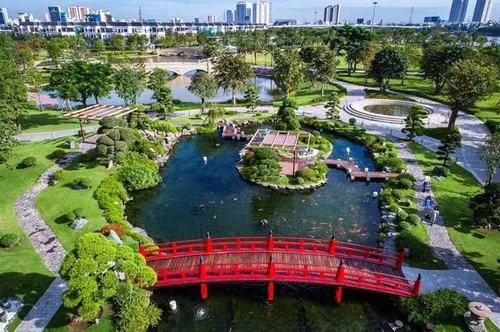 ảnh không gian xanh Vinhomes hồ nước lớn với đảo nhỏ giữa trung tâm, xung quanh là đường dạo và cây xanh, tạo góc nhìn cân đối khi chụp toàn cảnh từ trên cao