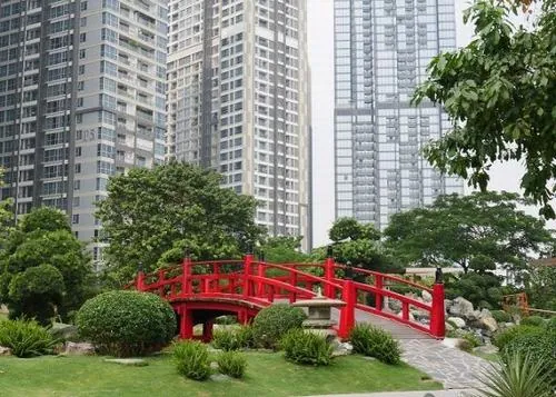 ảnh khu vườn ven sông lối đi giữa các tòa nhà cao tầng, cây xanh trồng đều hai bên, không gian sạch sẽ và thoáng, thích hợp dạo mát trong khu đô thị sang trọng