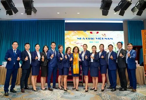 Đội ngũ nam nữ trẻ trung xếp hàng ngay ngắn giữa không gian sự kiện, ai cũng diện trang phục công sở chỉnh tề và giữ phong thái tự tin khi nhìn về máy ảnh