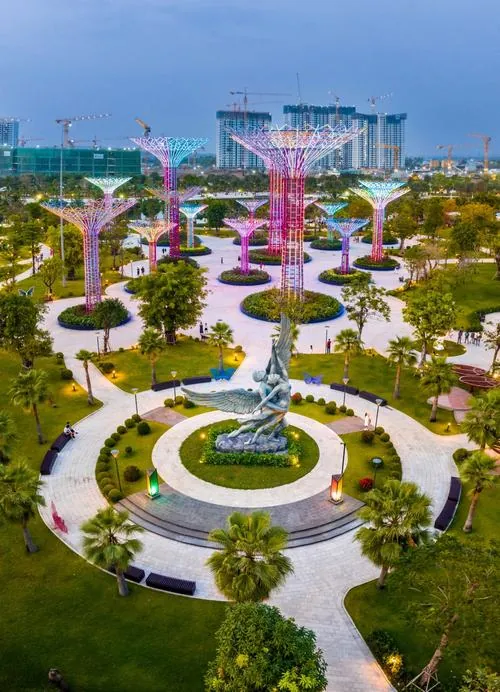 Ảnh dự án góc flycam ban ngày nhìn xuống công viên trung tâm xanh mát với lối đi uốn cong, hồ nước phản chiếu trời xanh, bao quanh là các tòa nhà thuộc khu đô thị Vin Quận 9