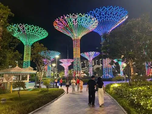 Khung cảnh buổi tối tại công viên ánh sáng với các cụm cây đèn đổi màu, người đi dạo và chụp ảnh đông đúc tạo nên góc check in công viên ánh sáng 36ha rất bắt mắt