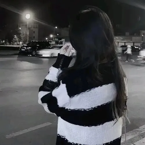 Hot girl ẩn mình ngồi trên ghế dài công viên dùng lá phong đỏ che mặt một bên, tóc thẳng đen dài óng ả, áo khoác denim khoe dáng thon gọn.