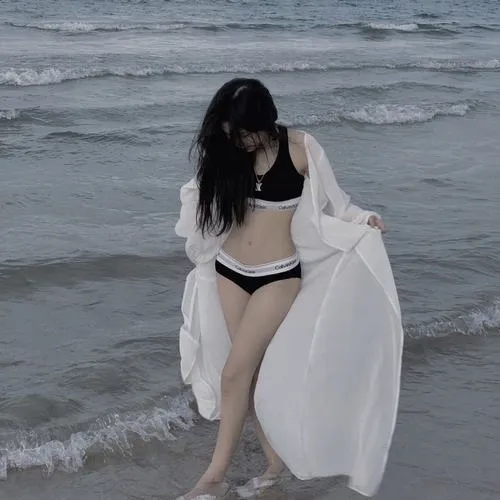 Mỹ nữ ngồi trên cát hồng hoàng hôn mặc bikini đỏ nhỏ tay chống sau lưng uốn eo cong người dưới ánh nắng dịu.