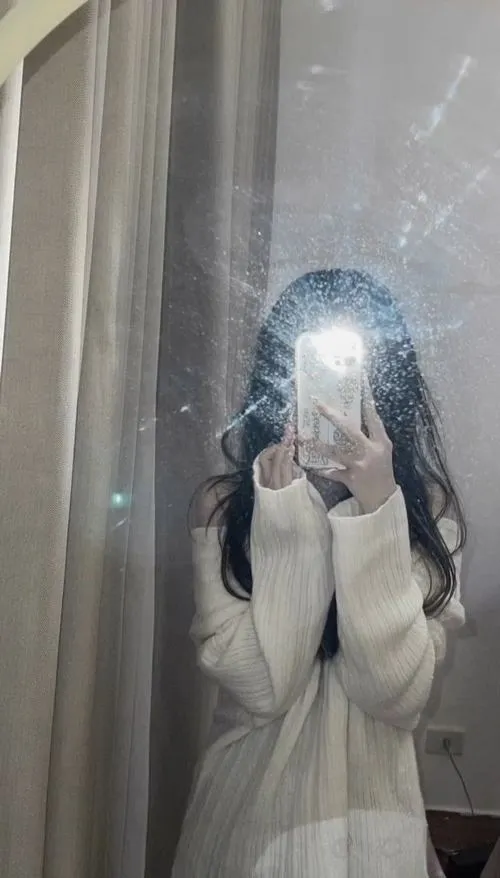 Mỹ nhân mặc áo vest đen quần âu cao cấp tóc búi gọn dùng điện thoại che mặt trong văn phòng.