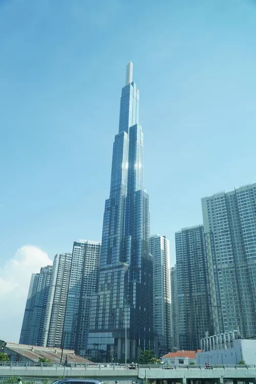 Ảnh chụp qua tán cây xanh, thân tháp lấp ló phía sau tạo cảm giác mềm mại hơn so với vẻ ngoài cứng cáp thường thấy