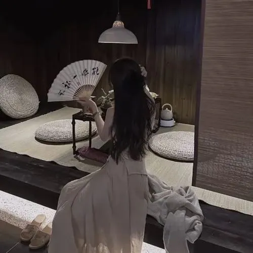 Hot girl che mặt nằm trên giường khách sạn sang cầm remote che miệng, tóc dài highlight vàng óng, áo silk satin mỏng manh.