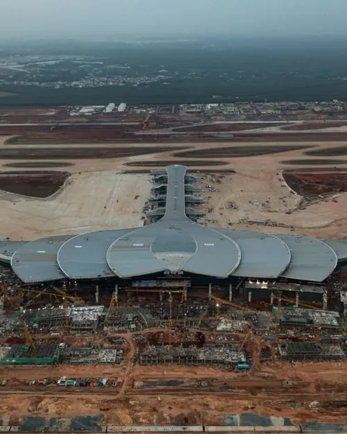 Ảnh nhà ga chụp chính diện khu trung tâm với mái cong xếp lớp như cánh sen, không gian công trình hàng không Long Thành hiện lên sáng và hơi hướng luxury trong bản phối cảnh