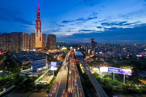Ảnh skyline thành phố nhìn từ khu vực cầu Sài Gòn khi trời vừa chạng vạng, nổi bật với Landmark 81 và ánh đèn đô thị phản chiếu khắp đường phố