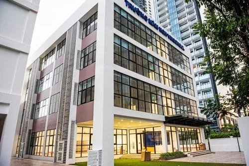 chung cư hạng sang Ba Son khối nhà thấp tầng với mặt tiền kính và cây xanh phía trước, ánh sáng ban ngày làm không gian trông rất sáng và đẹp