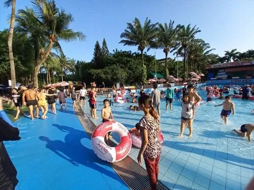 Khung cảnh công viên nước Đầm Sen ban ngày với hồ đông kín người, trẻ em vui đùa dưới vòi nước tạo nên bức ảnh cực kỳ sinh động