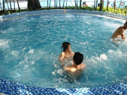 Góc nhìn tại công viên nước Đầm Sen hướng thẳng vào hồ rộng, một người đang bơi giữa làn nước trong tạo cảm giác thư giãn rõ rệt