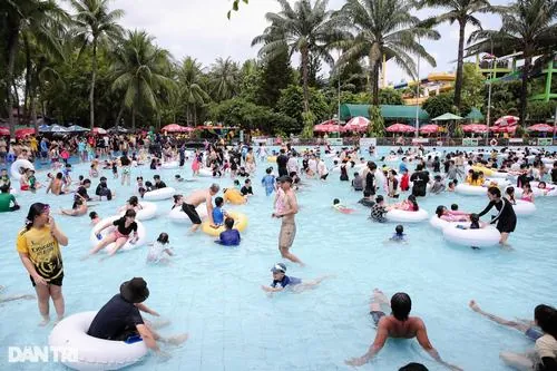 Hồ đông người với nhiều nhóm tụ tập vui đùa, từng đợt sóng nhẹ khiến ai cũng cười nói rôm rả không ngớt